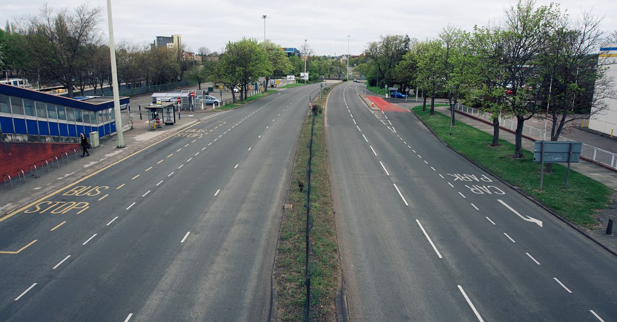 An empty UK dual carriageway with a bus stop lane and 'CAR PARK' road markings, seen from above.