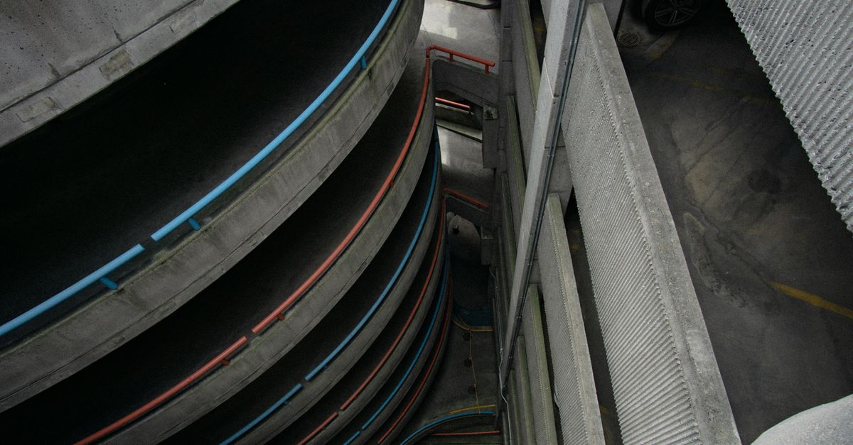 The curving concrete ramps and railings inside a multi-storey car park.